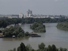 Der Zusammenfluss von Sava und Donau, im Hintergrund brutalistische Architektur in Neu-Belgrad