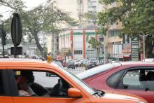 An Orange herrscht im Stadtbild von Abidjan kein Mangel, im Vordergrund ein Taxi (Suzuki S-Presso), das über seine Farbe signalisiert für ganz Abidjan lizenziert zu sein. Taxis sind ansonsten auch farblich an die jeweilige Gemeinde gebunden.